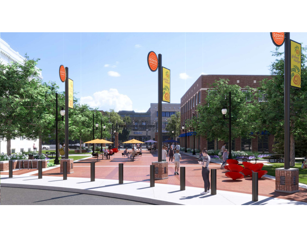 A curved sidewalk with bollards and street poles overlooking a paved park area